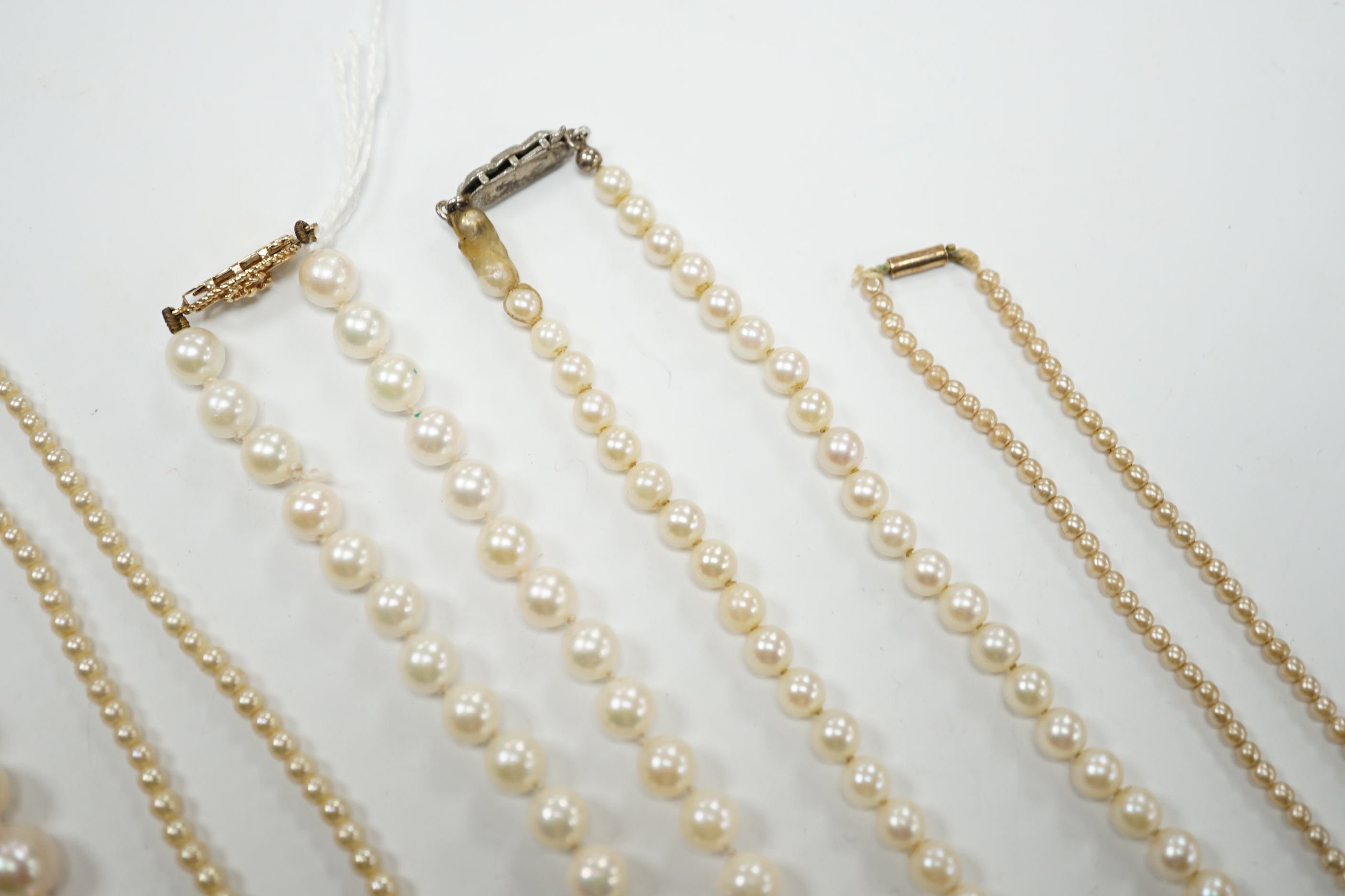 Five assorted single strand cultured pearl necklaces, including four with 9ct clasps, largest 47cm and one other simulated pearl necklace.
